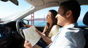 A Sri Lankan couple navigating a road trip in the United States with a map.